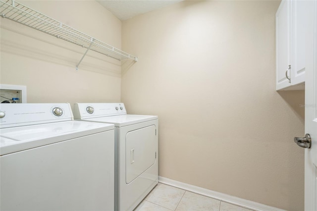 11839 Castine St, New Port Richey, FL 34654 - laundry room featuring washer and dryer, cabinet space, baseboards, and light tile patterned floors