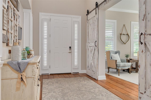 152 Glenn Moor Cir, Dunedin, FL 34698 - entryway with a barn door, hardwood / wood-style floors, crown molding, and baseboards