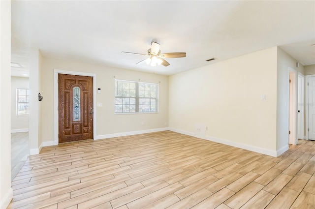 2121 23rd St SW, Largo, FL 33774 - foyer with a ceiling fan, light wood-style flooring, and baseboards