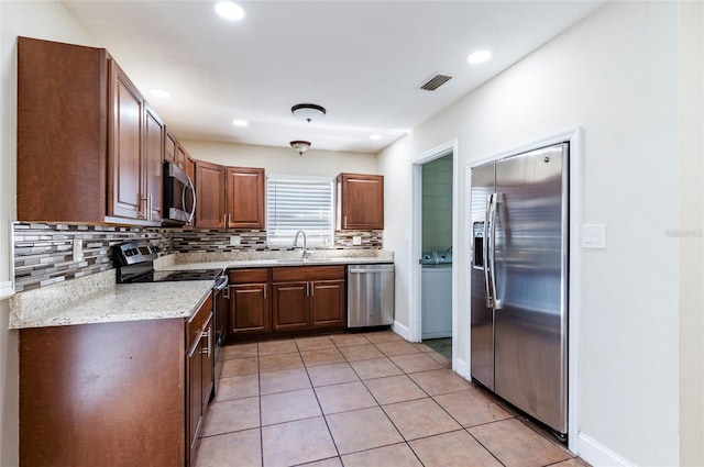 2121 23rd St SW, Largo, FL 33774 - kitchen with stainless steel appliances, decorative backsplash, a sink, light tile patterned flooring, and recessed lighting