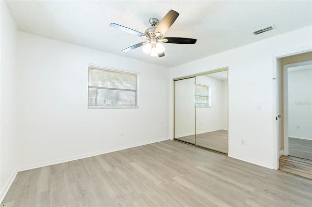 2121 23rd St SW, Largo, FL 33774 - unfurnished bedroom featuring light wood-style flooring, a closet, baseboards, and ceiling fan