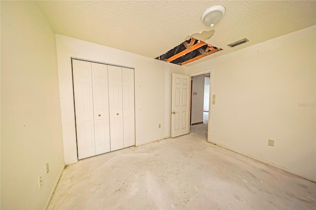 7033 Wentworth Way, New Port Richey, FL 34655 - unfurnished bedroom with unfinished concrete floors, a closet, and a textured ceiling