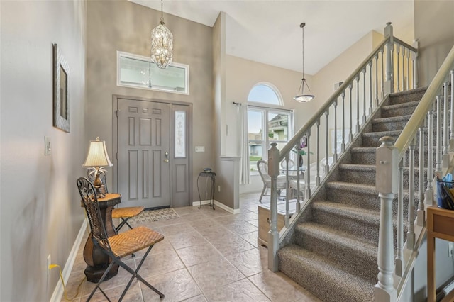 9322 Via Segovia, New Port Richey, FL 34655 - foyer entrance with baseboards, stairs, a chandelier, a high ceiling, and tile patterned floors