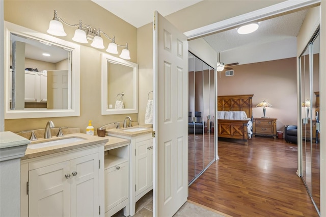 9322 Via Segovia, New Port Richey, FL 34655 - ensuite bathroom with vanity, wood finished floors, and a ceiling fan