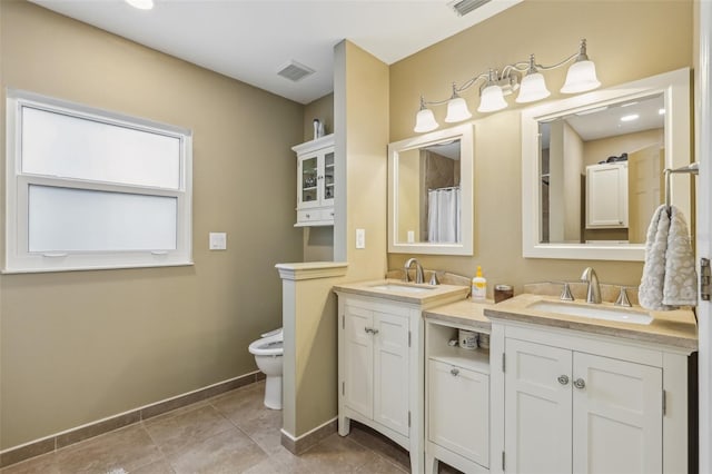 9322 Via Segovia, New Port Richey, FL 34655 - bathroom featuring double vanity, toilet, baseboards, and tile patterned floors