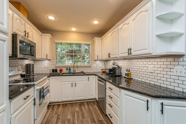4021 Vana Dr, Sarasota, FL 34241 - kitchen featuring stainless steel appliances, a sink, dark wood-type flooring, white cabinetry, and backsplash