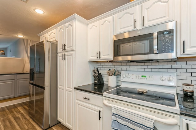 4021 Vana Dr, Sarasota, FL 34241 - kitchen with appliances with stainless steel finishes, dark countertops, recessed lighting, white cabinetry, and dark wood-style floors