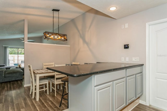 4021 Vana Dr, Sarasota, FL 34241 - kitchen with dark countertops, dark wood-type flooring, a peninsula, pendant lighting, and open floor plan