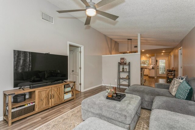 4021 Vana Dr, Sarasota, FL 34241 - living area featuring vaulted ceiling, a textured ceiling, light wood-style flooring, ceiling fan, and baseboards