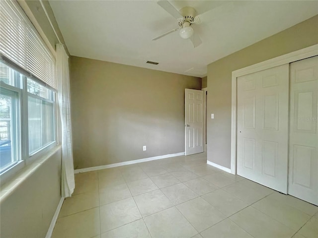 72 Lake Shore Dr, Palm Harbor, FL 34684 - unfurnished bedroom with a closet, light tile patterned flooring, and a ceiling fan