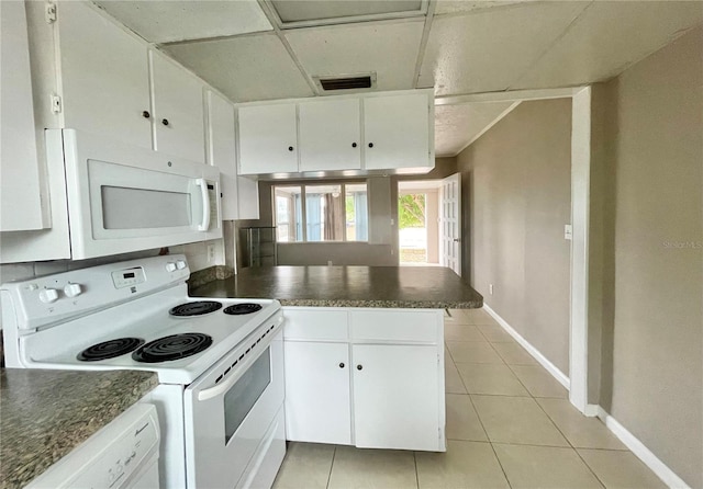 72 Lake Shore Dr, Palm Harbor, FL 34684 - kitchen with white appliances, a peninsula, dark countertops, and light tile patterned floors