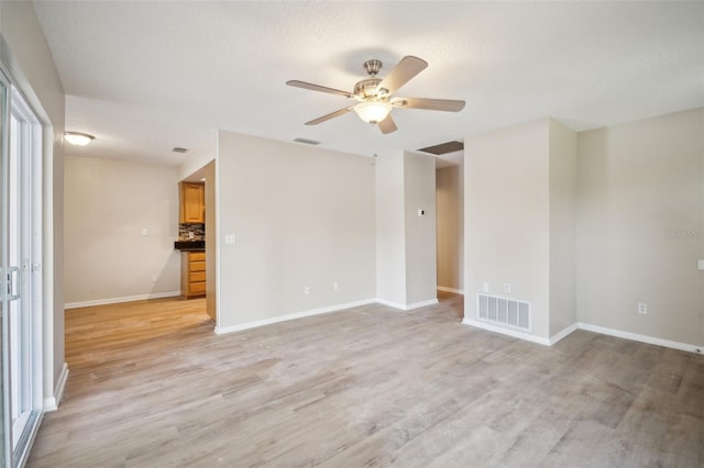 15202 Morning Dr, Lutz, FL 33559 - spare room featuring light wood-style floors, a ceiling fan, baseboards, and a textured ceiling