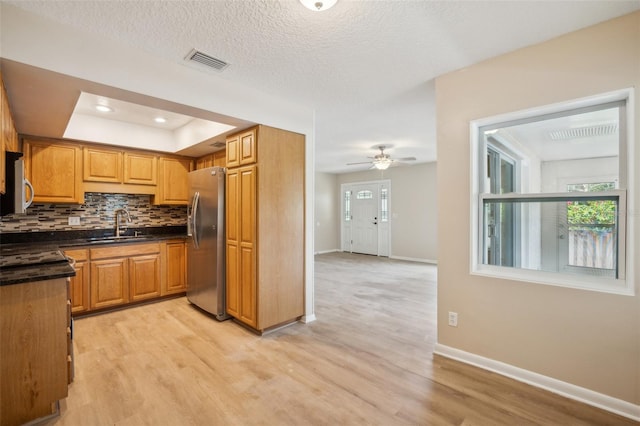 15202 Morning Dr, Lutz, FL 33559 - kitchen with appliances with stainless steel finishes, dark countertops, light wood finished floors, baseboards, and a tray ceiling