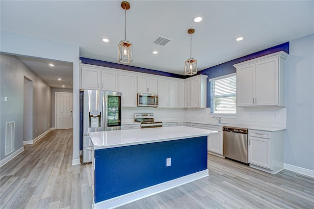 6119 Bradford Woods Dr, Zephyrhills, FL 33542 - kitchen with stainless steel appliances, a sink, white cabinetry, a center island, and recessed lighting