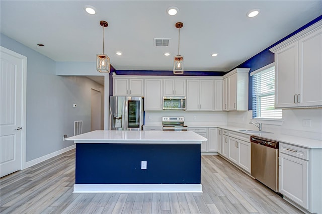 6119 Bradford Woods Dr, Zephyrhills, FL 33542 - kitchen featuring stainless steel appliances, a center island, a sink, light countertops, and light wood-style floors