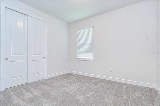 6119 Bradford Woods Dr, Zephyrhills, FL 33542 - unfurnished bedroom with carpet, baseboards, and a closet