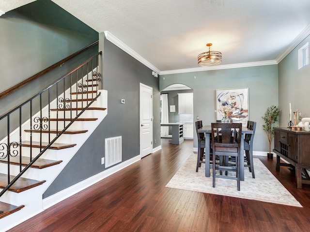 3003 W Leila Ave, Tampa, FL 33611 - dining area featuring arched walkways, wood finished floors, ornamental molding, stairway, and baseboards