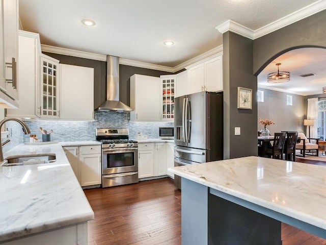 3003 W Leila Ave, Tampa, FL 33611 - kitchen featuring appliances with stainless steel finishes, wall chimney range hood, a sink, ornamental molding, and backsplash