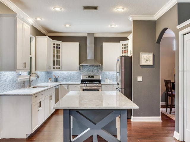 3003 W Leila Ave, Tampa, FL 33611 - kitchen with stainless steel appliances, wall chimney range hood, a sink, arched walkways, and dark wood-style floors