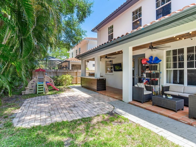 3003 W Leila Ave, Tampa, FL 33611 - view of patio featuring ceiling fan, an outdoor living space, and a playground