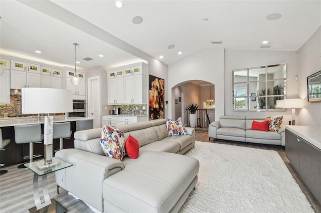 17 Franklin Ct S Unit C, Saint Petersburg, FL 33711 - living room featuring arched walkways, wood finished floors, recessed lighting, and lofted ceiling