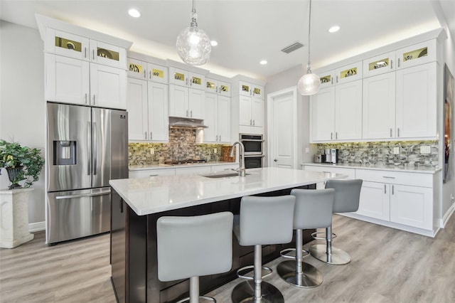 17 Franklin Ct S Unit C, Saint Petersburg, FL 33711 - kitchen with stainless steel appliances, a sink, under cabinet range hood, light countertops, and light wood-style floors