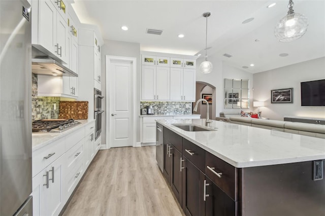 17 Franklin Ct S Unit C, Saint Petersburg, FL 33711 - kitchen featuring a sink, arched walkways, appliances with stainless steel finishes, glass insert cabinets, and light wood finished floors