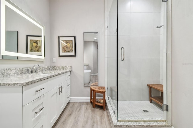 17 Franklin Ct S Unit C, Saint Petersburg, FL 33711 - bathroom with a shower stall, vanity, wood finished floors, and baseboards