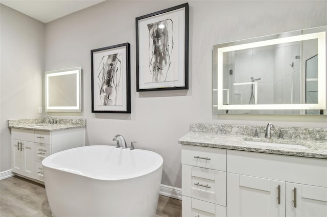 17 Franklin Ct S Unit C, Saint Petersburg, FL 33711 - bathroom featuring two vanities, a stall shower, baseboards, and a soaking tub
