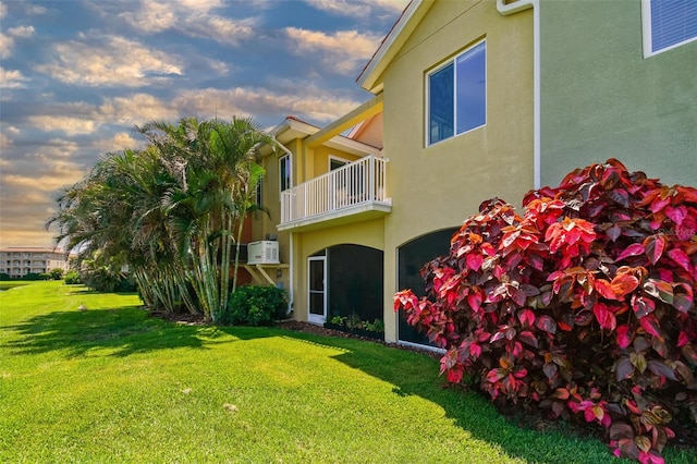 17 Franklin Ct S Unit C, Saint Petersburg, FL 33711 - property exterior at dusk with stucco siding, a lawn, and a balcony