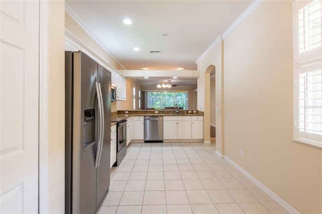 21209 Diamonte Dr, Land O Lakes, FL 34637 - kitchen featuring appliances with stainless steel finishes, ornamental molding, dark countertops, light tile patterned floors, and white cabinets