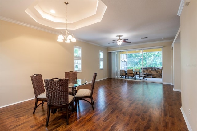 21209 Diamonte Dr, Land O Lakes, FL 34637 - dining space featuring dark wood-type flooring, ornamental molding, baseboards, a ceiling fan, and a tray ceiling