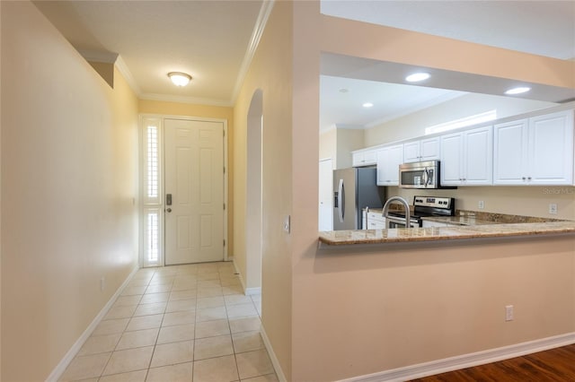 21209 Diamonte Dr, Land O Lakes, FL 34637 - kitchen with appliances with stainless steel finishes, crown molding, light stone counters, white cabinetry, and baseboards