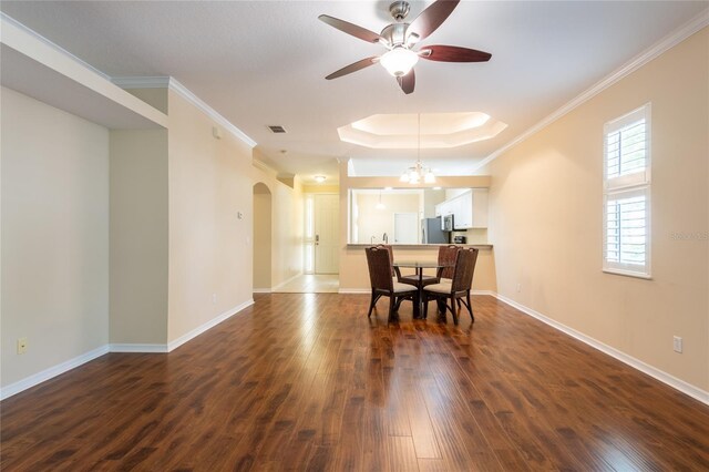 21209 Diamonte Dr, Land O Lakes, FL 34637 - dining room featuring arched walkways, ceiling fan, dark wood-style flooring, crown molding, and a tray ceiling