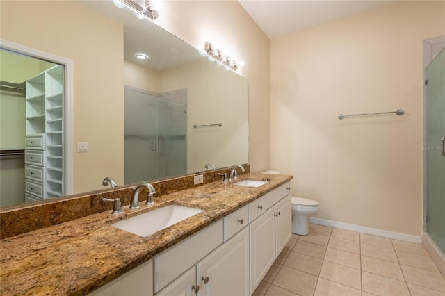 21209 Diamonte Dr, Land O Lakes, FL 34637 - bathroom with a shower stall, baseboards, a spacious closet, double vanity, and tile patterned floors