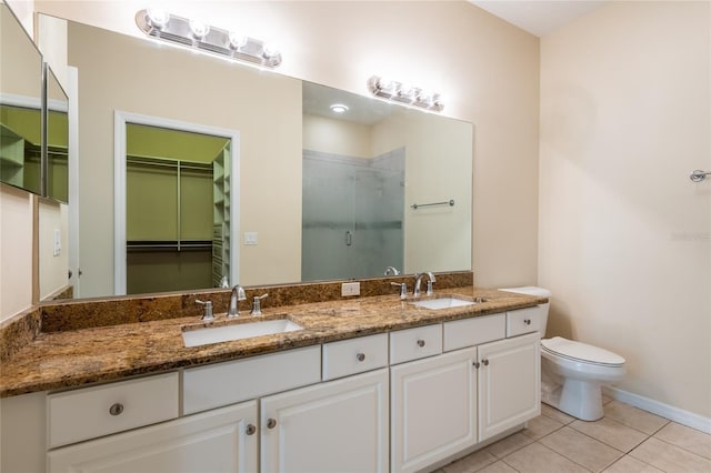 21209 Diamonte Dr, Land O Lakes, FL 34637 - bathroom featuring a stall shower, double vanity, a spacious closet, toilet, and tile patterned flooring
