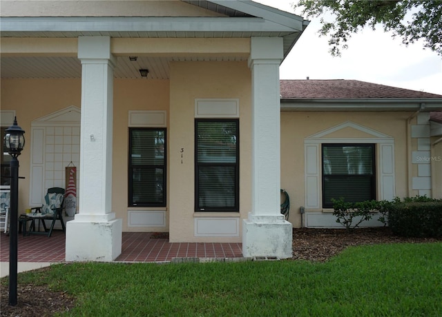 311 Kelsey Way Unit 3, Sun City Center, FL 33573 - view of exterior entry with stucco siding, covered porch, and a shingled roof