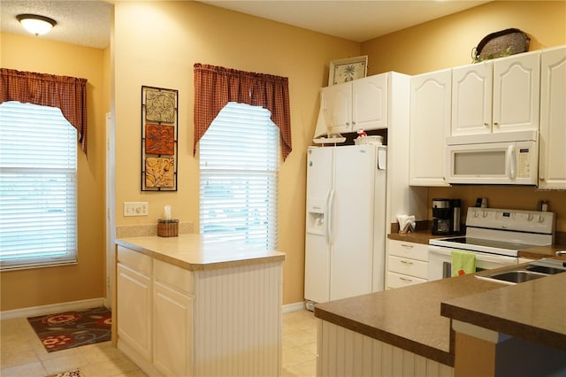311 Kelsey Way Unit 3, Sun City Center, FL 33573 - kitchen featuring white appliances, a peninsula, white cabinets, and dark countertops