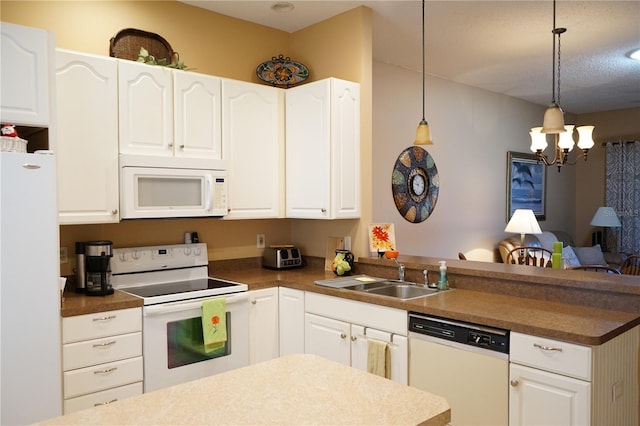 311 Kelsey Way Unit 3, Sun City Center, FL 33573 - kitchen featuring white appliances, a peninsula, a chandelier, and white cabinetry