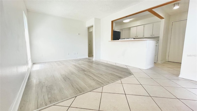 501 E Bay Dr Unit 3504, Largo, FL 33770 - unfurnished living room with a textured ceiling, baseboards, and light tile patterned floors