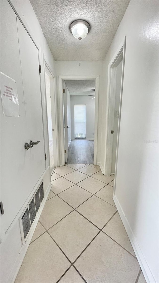 501 E Bay Dr Unit 3504, Largo, FL 33770 - hall featuring a textured ceiling, light tile patterned floors, and baseboards