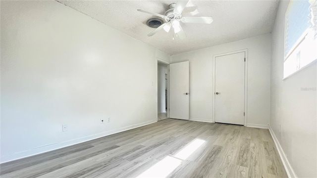 501 E Bay Dr Unit 3504, Largo, FL 33770 - unfurnished bedroom featuring a textured ceiling, light wood-type flooring, baseboards, and a ceiling fan