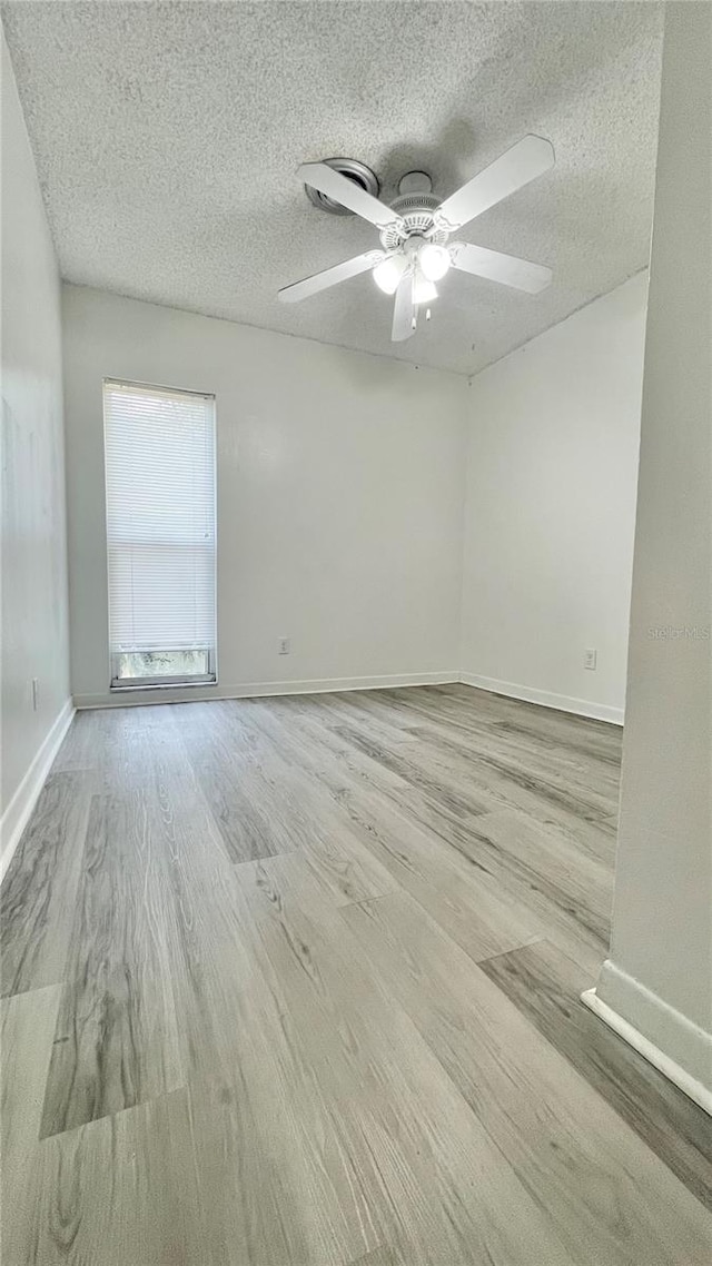 501 E Bay Dr Unit 3504, Largo, FL 33770 - spare room featuring wood finished floors, a textured ceiling, ceiling fan, and baseboards
