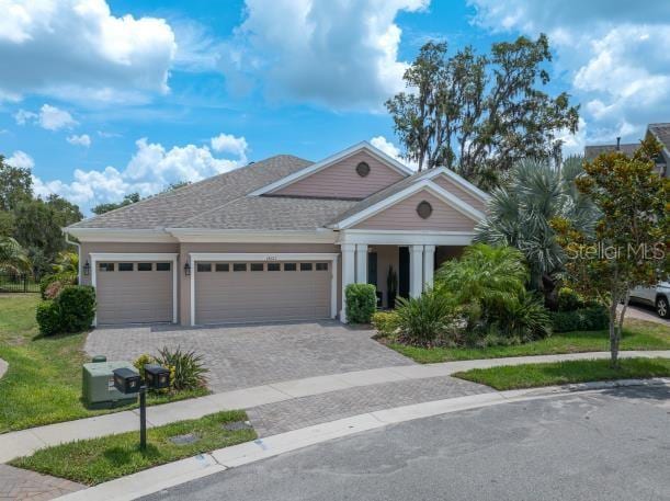 14223 Lambert Bridge Ln, Lithia, FL 33547 - view of front of property with a garage, decorative driveway, and roof with shingles