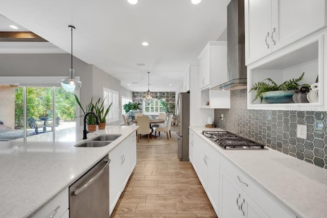 14223 Lambert Bridge Ln, Lithia, FL 33547 - kitchen featuring a sink, appliances with stainless steel finishes, wall chimney range hood, light countertops, and light wood finished floors