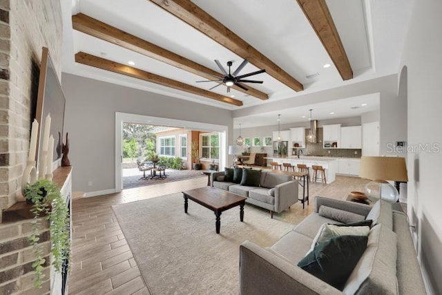 14223 Lambert Bridge Ln, Lithia, FL 33547 - living area with a ceiling fan, beam ceiling, light wood finished floors, and baseboards