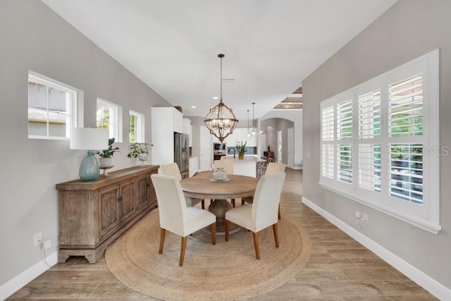 14223 Lambert Bridge Ln, Lithia, FL 33547 - dining room featuring a chandelier, arched walkways, baseboards, and light wood-type flooring