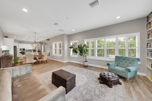 14223 Lambert Bridge Ln, Lithia, FL 33547 - living area featuring light wood-style flooring, recessed lighting, baseboards, and a chandelier