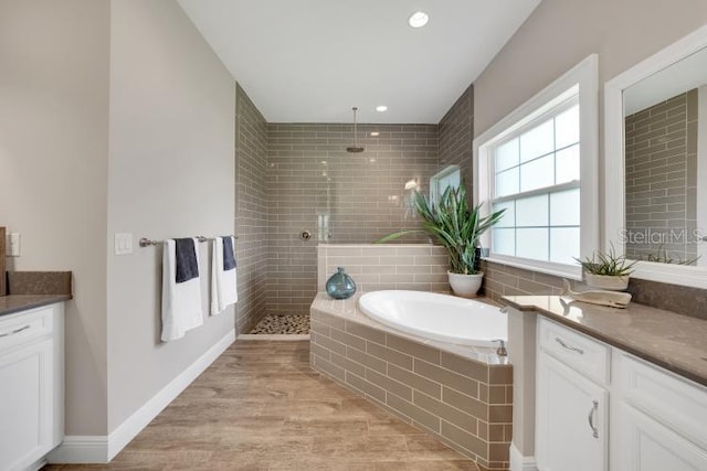 14223 Lambert Bridge Ln, Lithia, FL 33547 - full bath featuring vanity, a walk in shower, a bath, wood finished floors, and recessed lighting