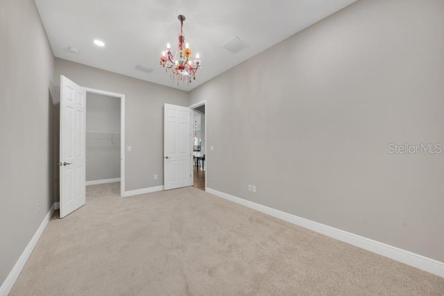 14223 Lambert Bridge Ln, Lithia, FL 33547 - unfurnished bedroom with light carpet, a chandelier, baseboards, a walk in closet, and a closet